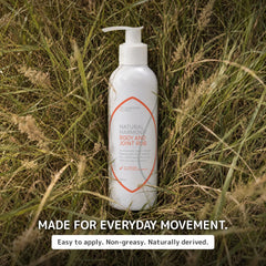 A white pump bottle of Natural Harmony Body and Joint R&B supplement placed upright in tall dry grass. The label features orange and gray text, and the image includes the text 'MADE FOR EVERYDAY MOVEMENT.